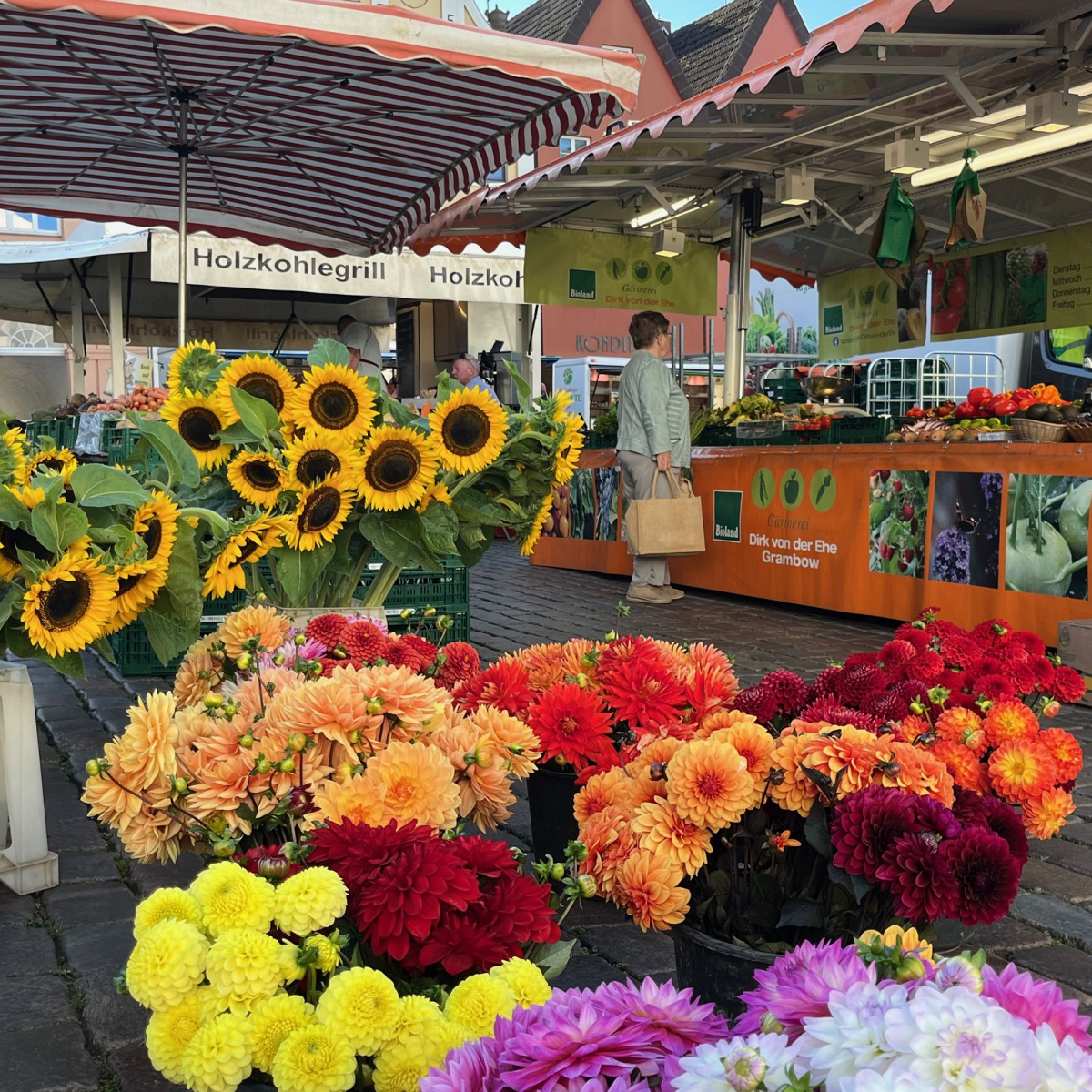 Stand auf dem Wochenmarkt mit Blumen im Vordergrund